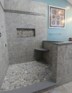 A walk in shower with tile.