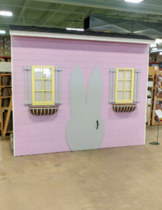 A shed with windows and a bunny-shaped door.