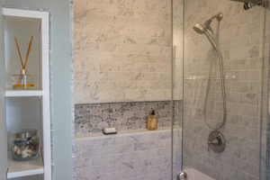 A shower with tile and a glass door.