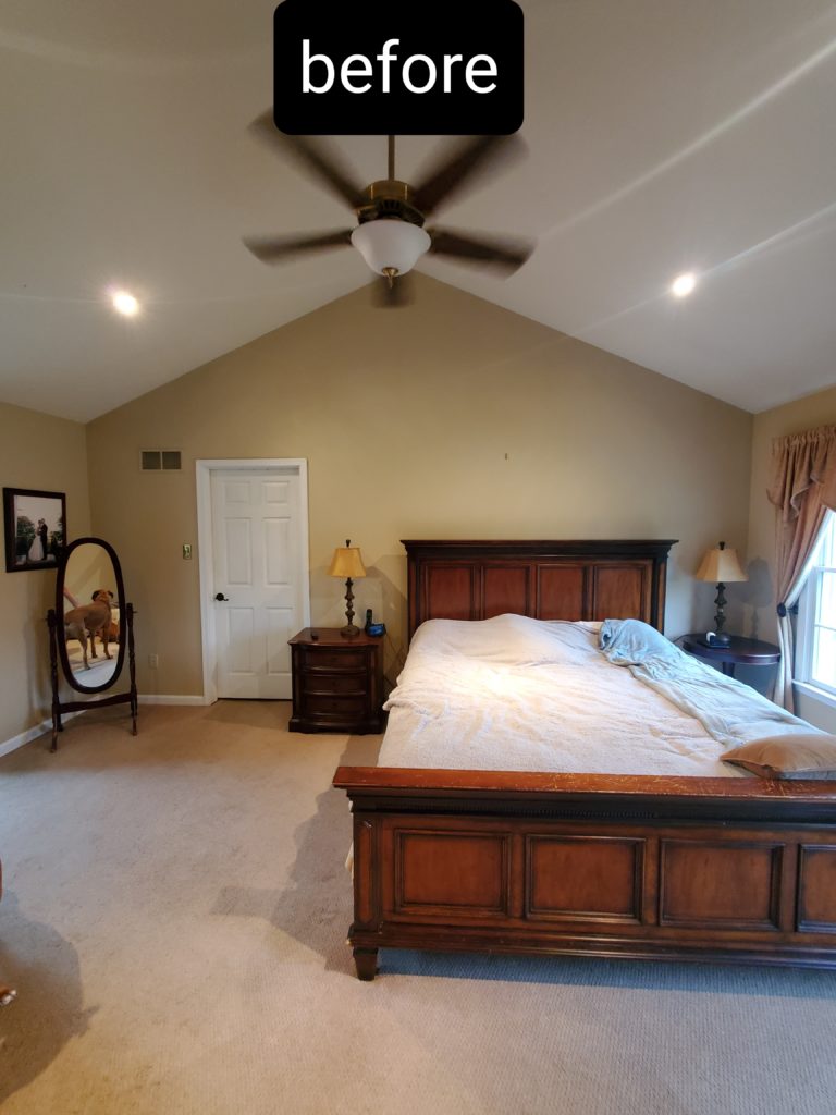 A master bedroom with a wooden bedframe prior to renovations
