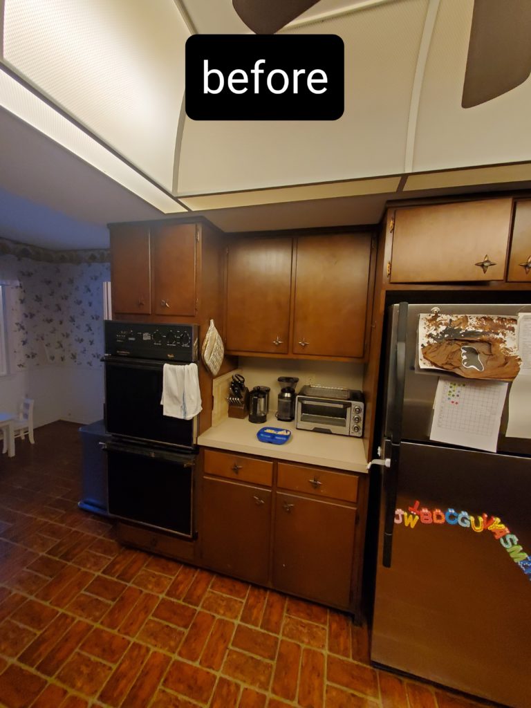 A small kitchen with wood cabinets prior to being renovated